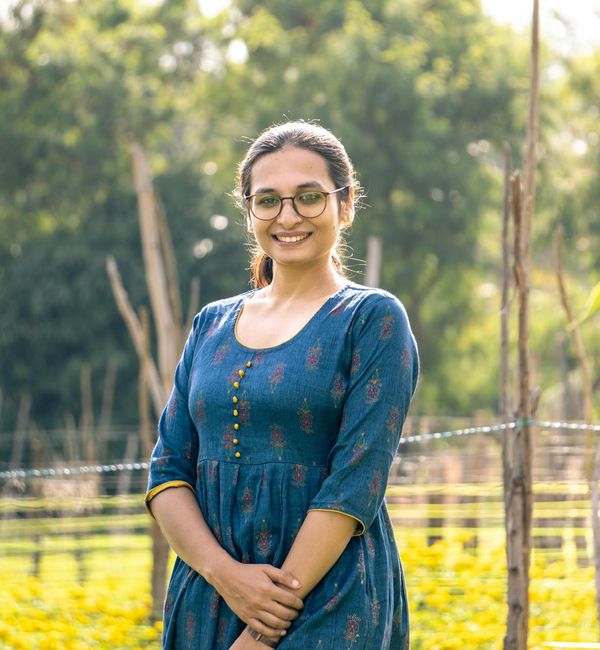 Smiling woman stretching outdoors during a sunny day.